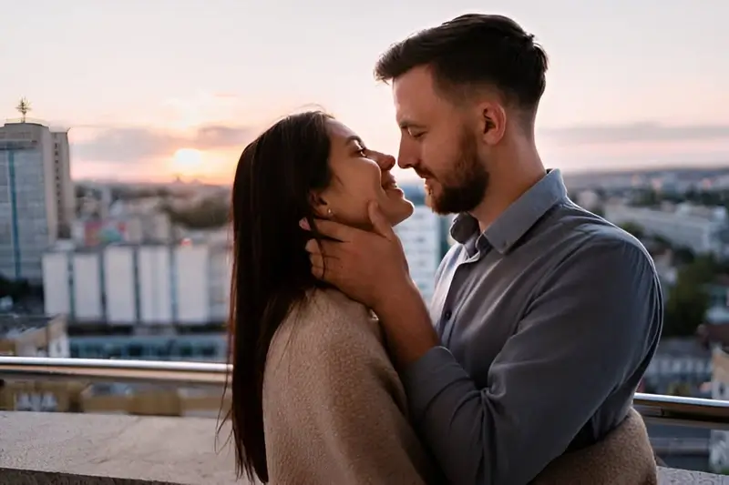 Man and woman on balcony at sunset