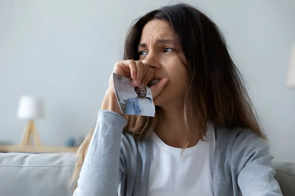 Close up crying woman holding picture of husband, break up